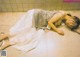 A woman laying on the floor in a white dress.