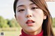 A woman with long brown hair wearing a red sweater.