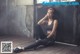 A woman sitting on the floor in a gym.