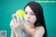 A woman holding a yellow tennis ball in her hand.