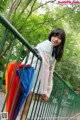 A woman standing on a bridge holding an umbrella.